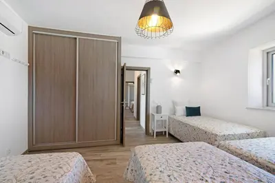 three beds in a room with white walls at Villa Flora in Algoz