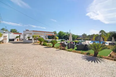 a swimming pool with two lounge chairs and a patio at Villa Assumadas in Ferreiras