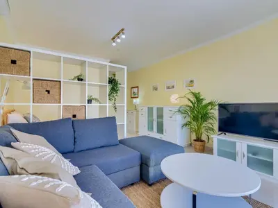 a living room with a blue couch and a tv at AL - Apartamento Falésia Terrace in Vilamoura