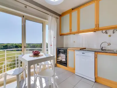 a kitchen with a table and chairs and a balcony at AL - Apartamento Falésia Terrace in Vilamoura