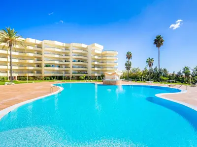 a large swimming pool in front of a large building at Luxury Penthouse wStunning Sea Views, walk to Galé Beach Albufeira in Albufeira