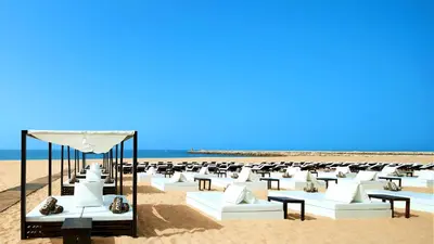 a beach with white chairs and tables on the sand at Vilamoura Marina Villa in Vilamoura