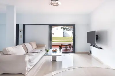 a living room with a white couch and a tv at Vilamoura Marina Villa in Vilamoura