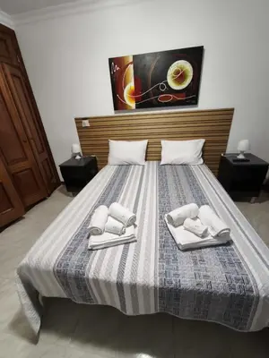a bedroom with a bed with two towels on it at Quarteira Apartamento T2 - Oceanides in Quarteira