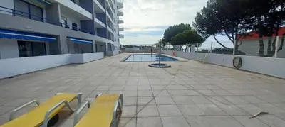 a building with a pool in the middle of a courtyard at Quarteira Apartamento T2 - Oceanides in Quarteira