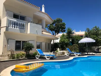 a house with a swimming pool in front of a house at Vila Luisa Anabela Piscine et Jacuzzi in Albufeira