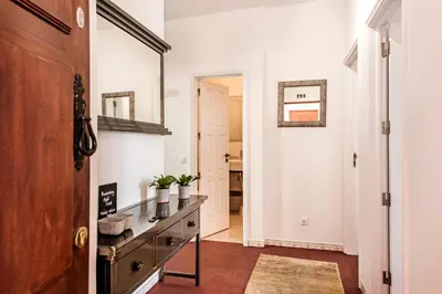 a hallway with a console table and a mirror at Spacious 3BR Apartment in Vilamoura Old Village with Rooftop BBQ, Pools & Panoramic Views in Quarteira
