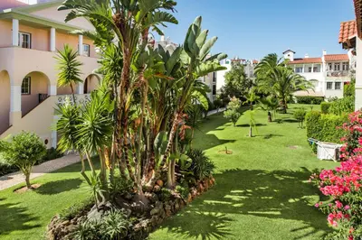 an apartment garden with palm trees and plants at Spacious 3BR Apartment in Vilamoura Old Village with Rooftop BBQ, Pools & Panoramic Views in Quarteira