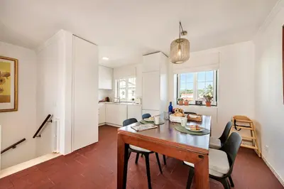 a kitchen and dining room with a table and chairs at Spacious 3BR Apartment in Vilamoura Old Village with Rooftop BBQ, Pools & Panoramic Views in Quarteira