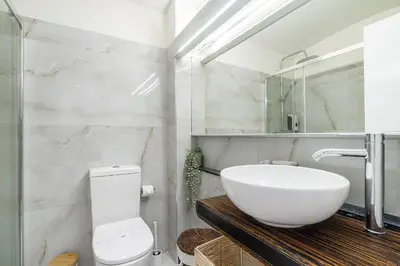 a white bathroom with a sink and a toilet at Sea & Oldtown View in Albufeira