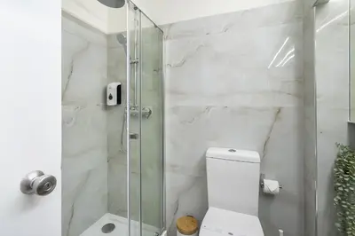 a bathroom with a toilet and a glass shower at Sea & Oldtown View in Albufeira
